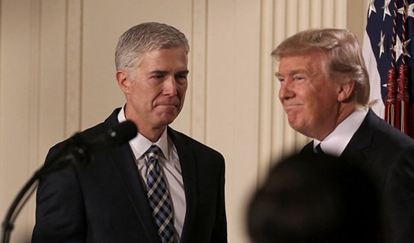U.S. President Donald Trump looks on as Neil Gorsuch (L) approaches the podium after being nominated to be an associate justice of the U.S. Supreme Court at the White House in Washington